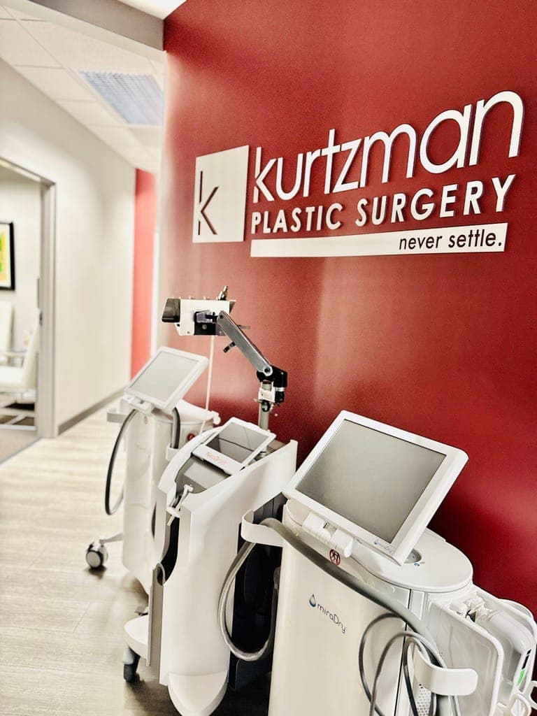 Hallway with Kurtzman Plastic Surgery wall logo and laser equipment